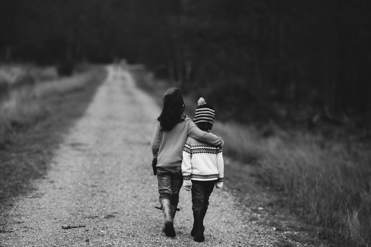 Deux enfants marchant bras dessus bras dessous sur un chemin