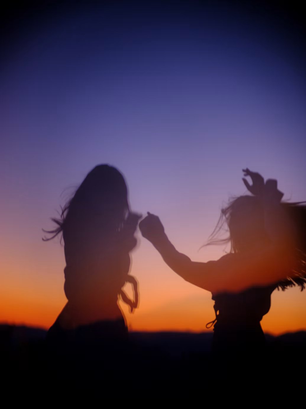 Deux silhouettes dansant au coucher du soleil